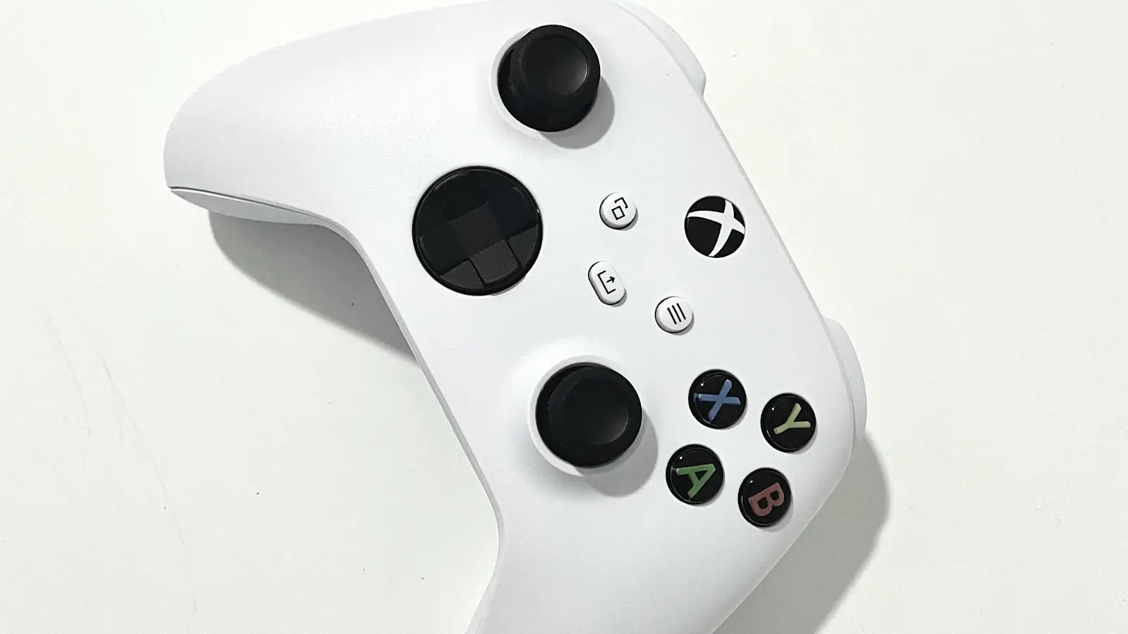 A white games controller photographed from above on a plain background