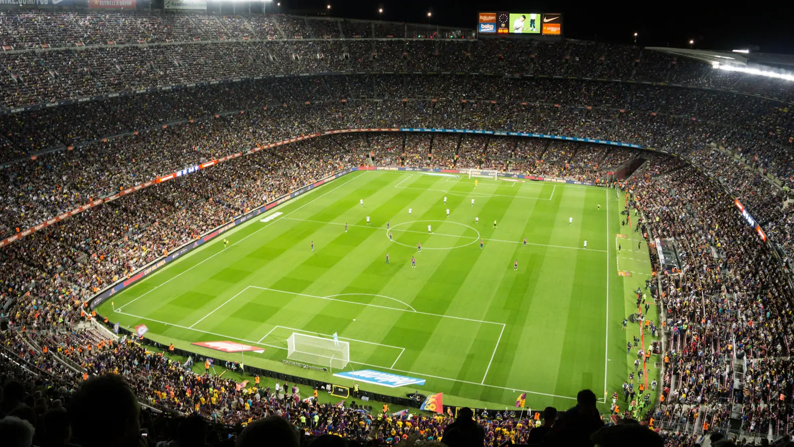 A packed football stadium under floodlights during a night match